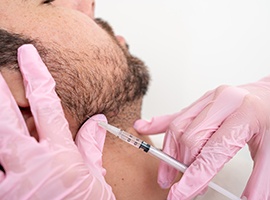 Man receiving injection near his jaw