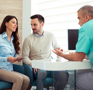 Man and woman talking to dentist